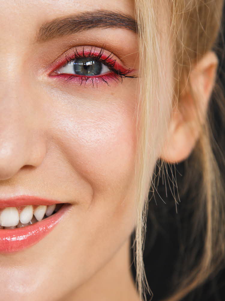 Nærbilde av halve ansiktet til en modell med rosa eyeliner og ferskenfargede lepper