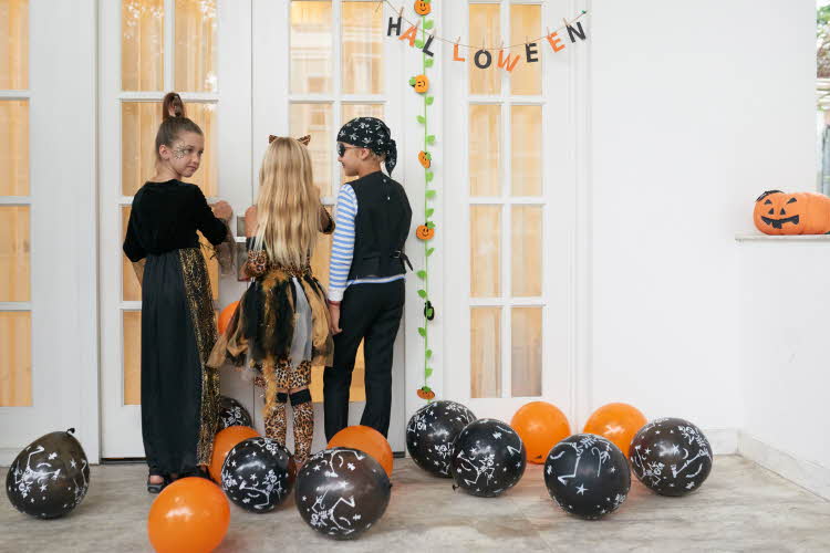 Tre barn og flere ballonger på gulvet