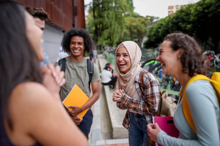 ungdommer som står utenfor skolen og ler