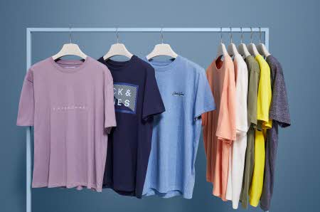 Et klesstativ hvor det henger flere t-skjorter med forskjellige farger og motiv
