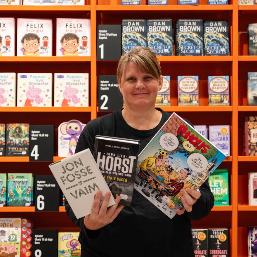 Dame fra ARK Bokhandel viser frem bøker