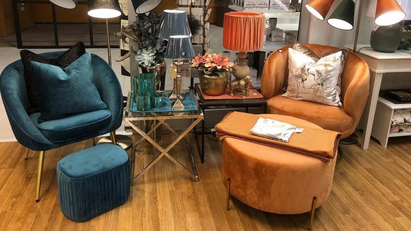 miljøbilde fra butikken, to sett med stol, puter og puff, et blått og et oransj
