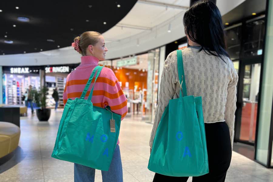 To jenter går med hvert sin shoppingbag over skulderen