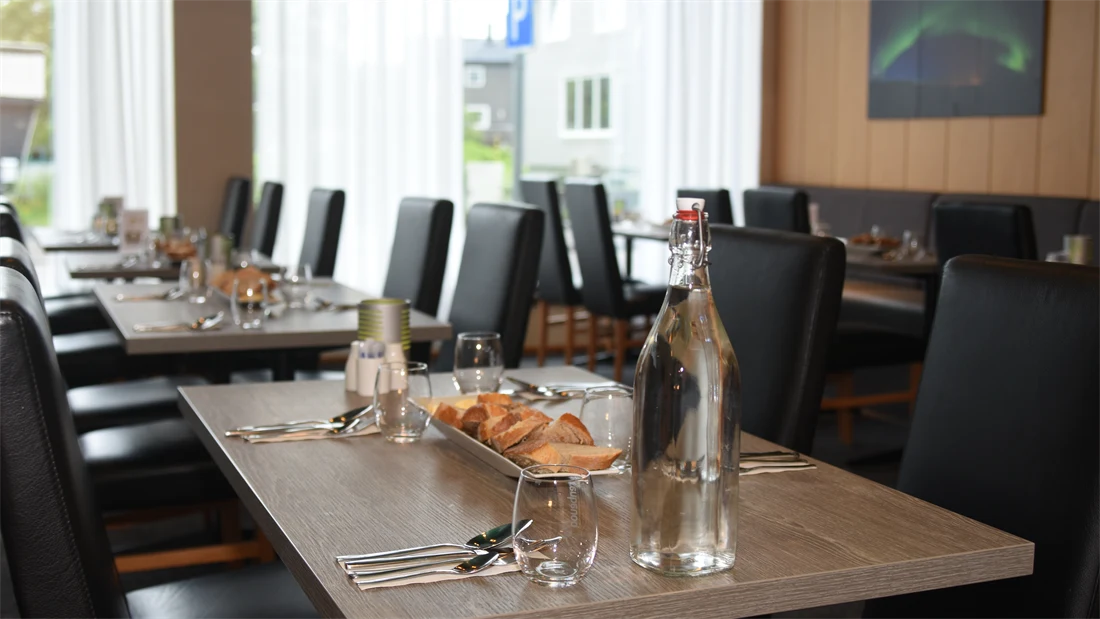 Konferanse og frokostsal, pådekket bord med glass, bestikk og bordpynt