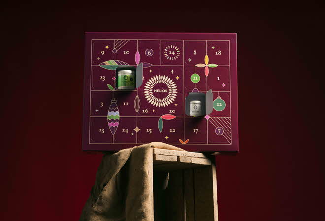 Helios adventskalender med lilla design og små åpne luker.