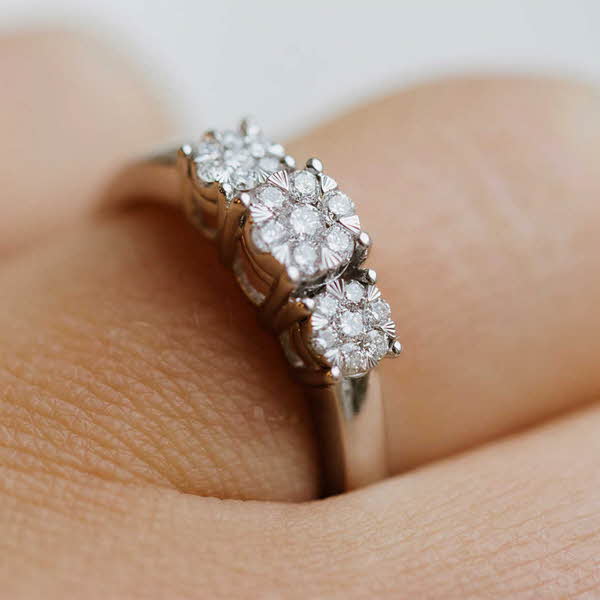hvit gull ring med diamanter på fingeren til en person