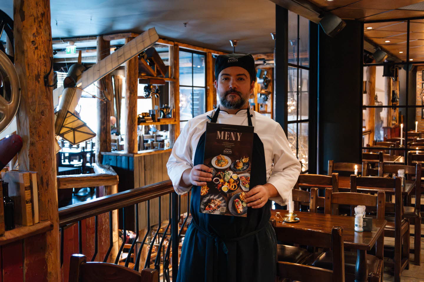 Ansatt på Egon viser frem menyen