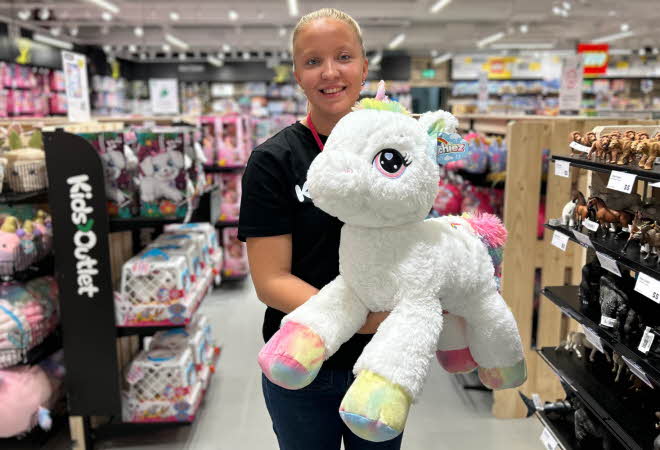 Dame som holder en stor enhjørningsbamse