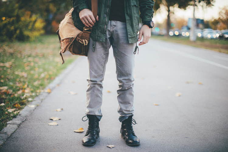 Halvprofil av mann med olabukse og svarte combat boots