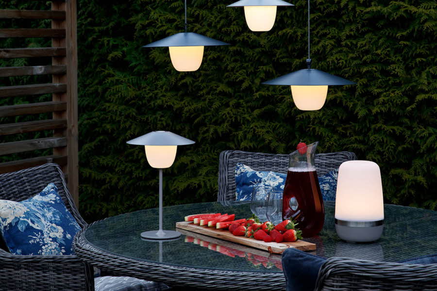 Lamper som henger over og står på et bord med jordbær i skumringen
