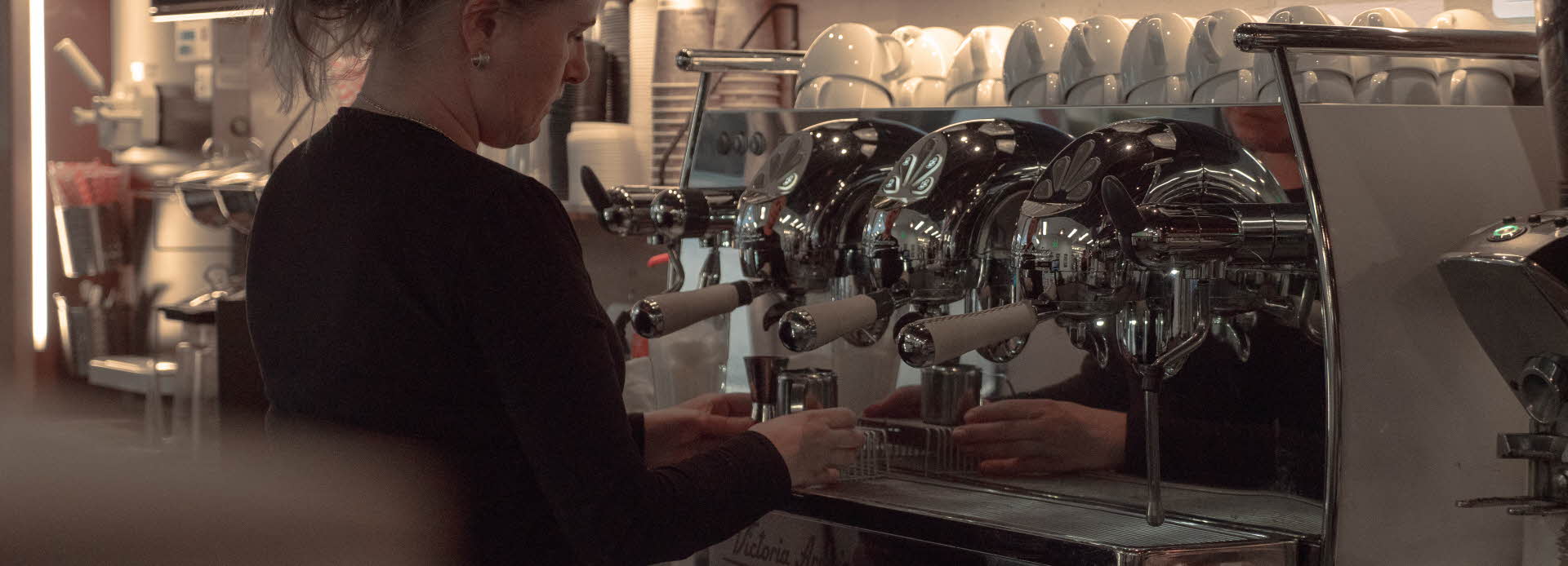 Bildet viser en som lager kaffe på et av spisestedene på kjøpesenteret AMFI Pyramiden. 