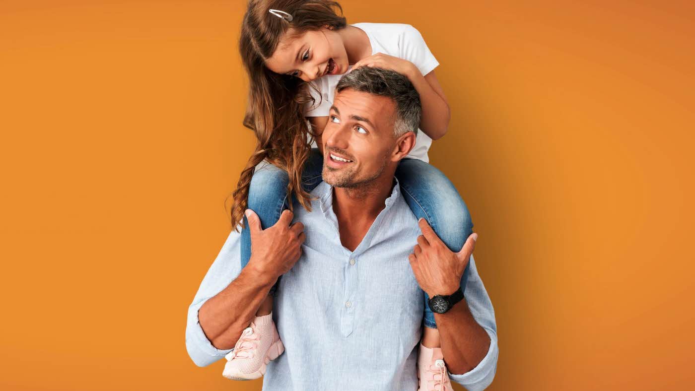 Far med datter sittende på skuldrene, oransje bakgrunn