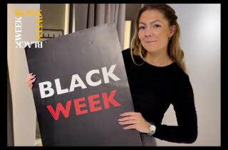 En dame som holder en Black Week-plakat