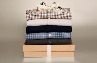 Stabel med fem flanellskjorter i ulike farger og mønstre.