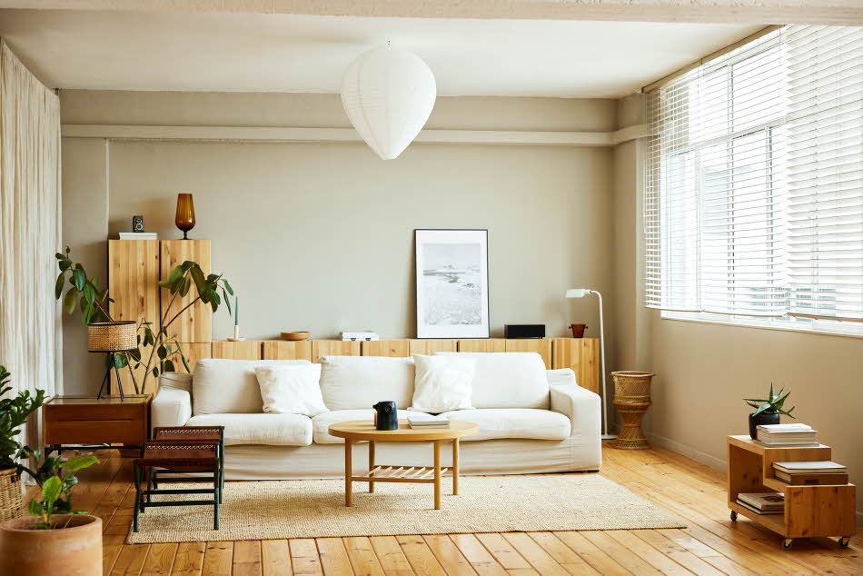 Stue med tremøbler, hvit sofa og stort gulvteppe i ull
