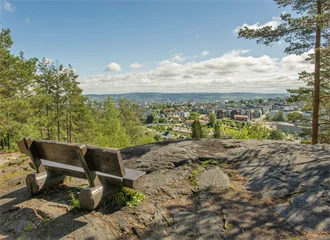 Bilde av en benk på et fjell, med utsikt over Strømmen