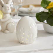 et hvit kermaikk egg med tulipan motiv som lyser
