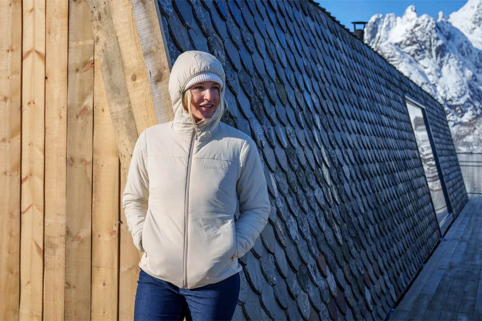 Dame i boblejakke med hvitkledde fjell i bakgrunn