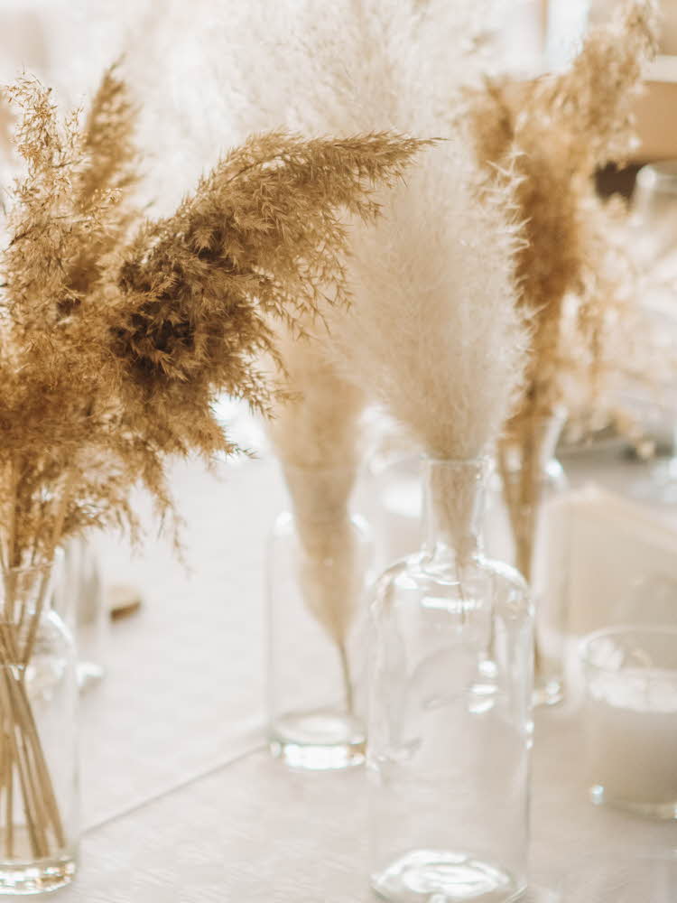 Blomsterbukett i vase med lys i bakgrunnen Hvete som står i vaser