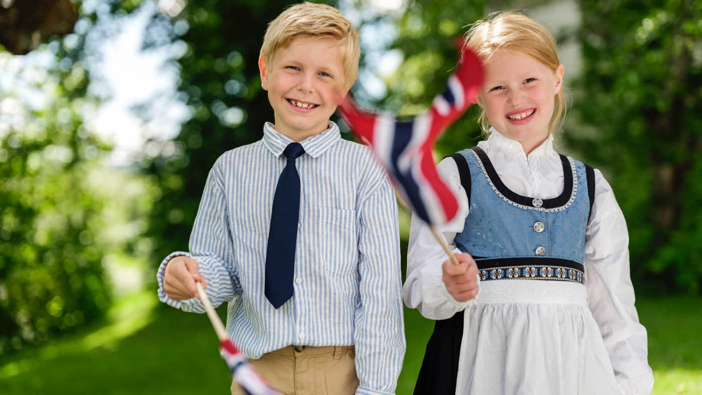 Glade barn med norske flagg