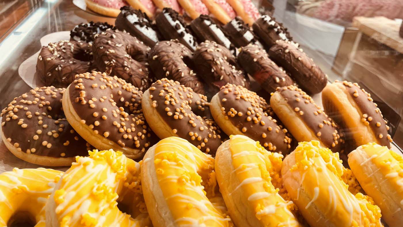 Bilde av mange forskjellige donuts på et fat.