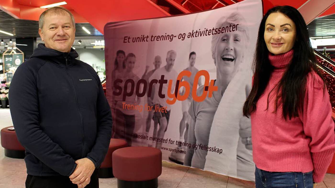 mann og dame som står foran en banner på storsenteret