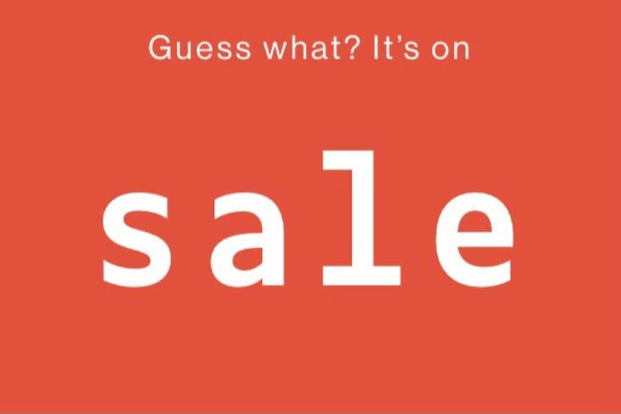 Hvit skrift på rød bakgrunn: "Guess what? It's on sale"