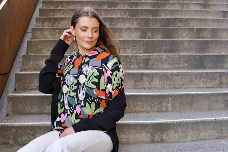 Dame med 70-talls inspirert jakke som sitter i en trapp