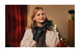 En kvinne med skinnhansker på som drar ned glidelåsen på en hals.