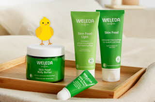 Weleda hudpleieprodukter på et trebrett med en gul kylling illustrasjon på lokket.
