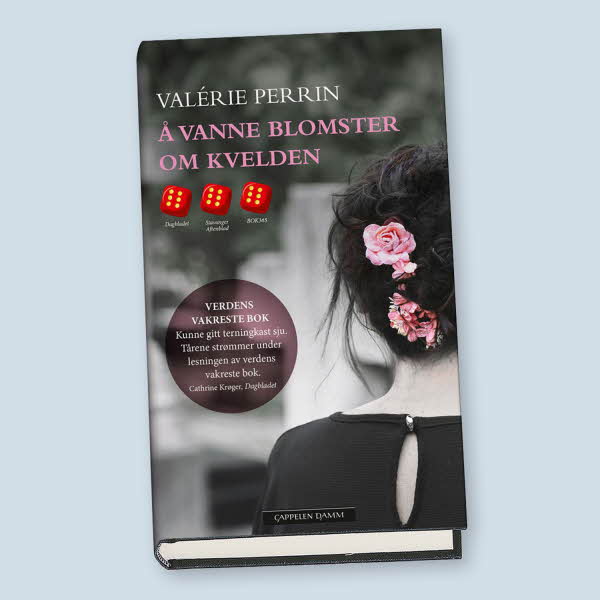 En bok i svart og hvitt av ryggen til en dame med rosa roser i håret