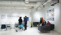 Utsnitt fra Kreftforeningens popup-lokale på Sartor, med sofaområde og utstilte bilder på veggen.