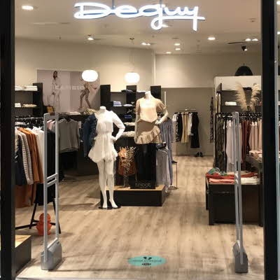 Bilde av inngangen til klesbutikken Deguy med vinduvisning med mannekeng og andre produkter