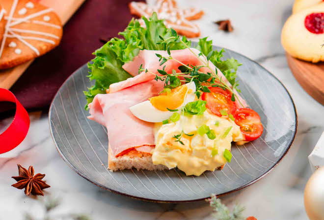 En asjett med et smørbrød med juleskinke og eggesalat