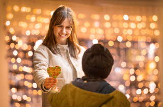 Dame som gir pepperkakehjerte til en gutt