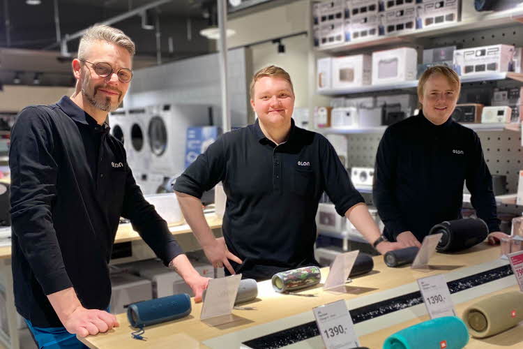 Tre av de ansatte på ELON står ved et bord i butikken