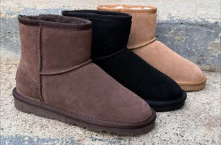 Støvler i brun, sort og beige står på en grå steintrapp