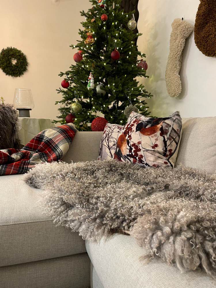 Pyntet sofa med et juletre i bakgrunn