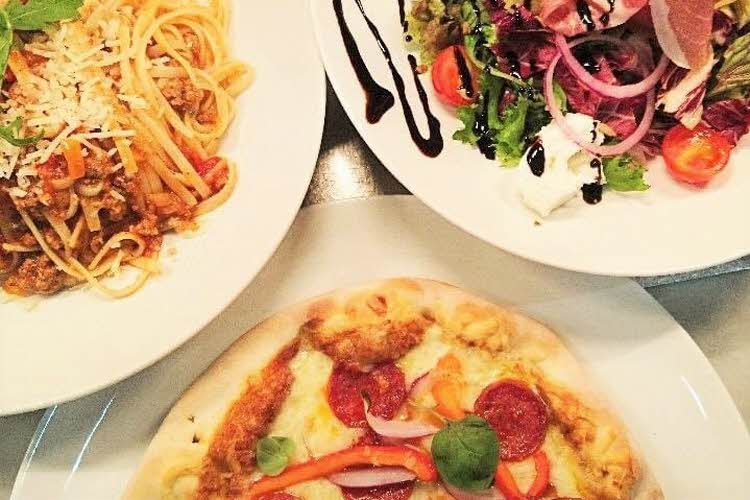 Tre tallerkener med pasta, pizza og salat