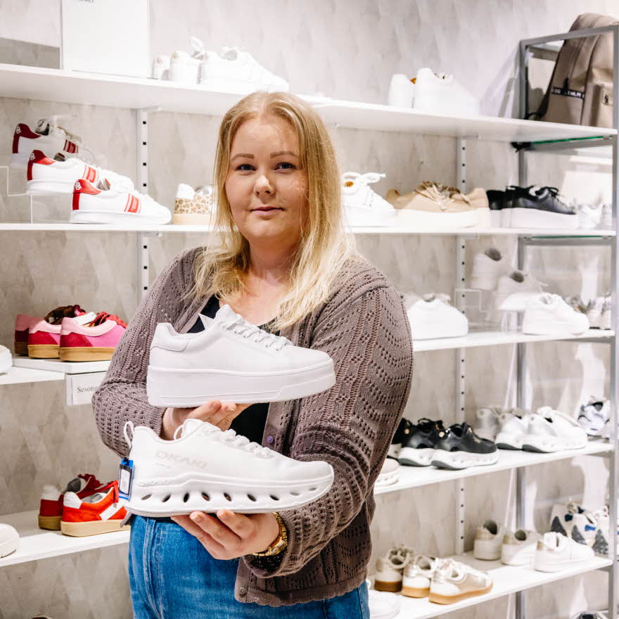 Dame som holder sneakers