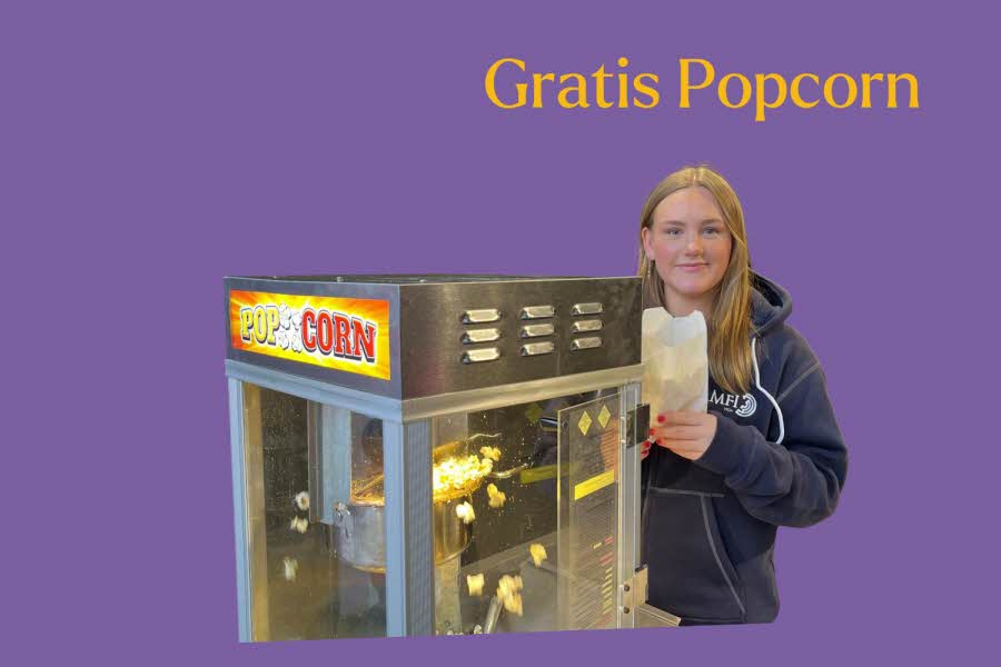 Jente står bak popcornmaskin, tekst: Gratis popcorn