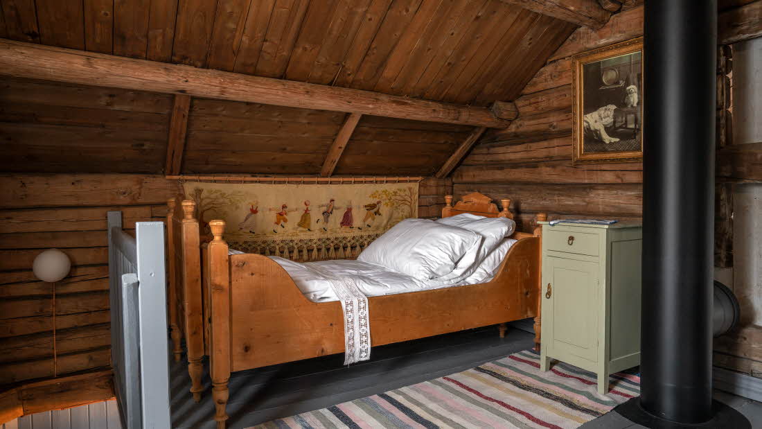 En av sengene på utsiden av soverommet, med tilhørende nattbord.