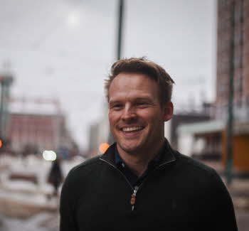 Bilde av Lars Eikeland Hagen i Oslo Sentrum. Han smiler mot kameraet. 