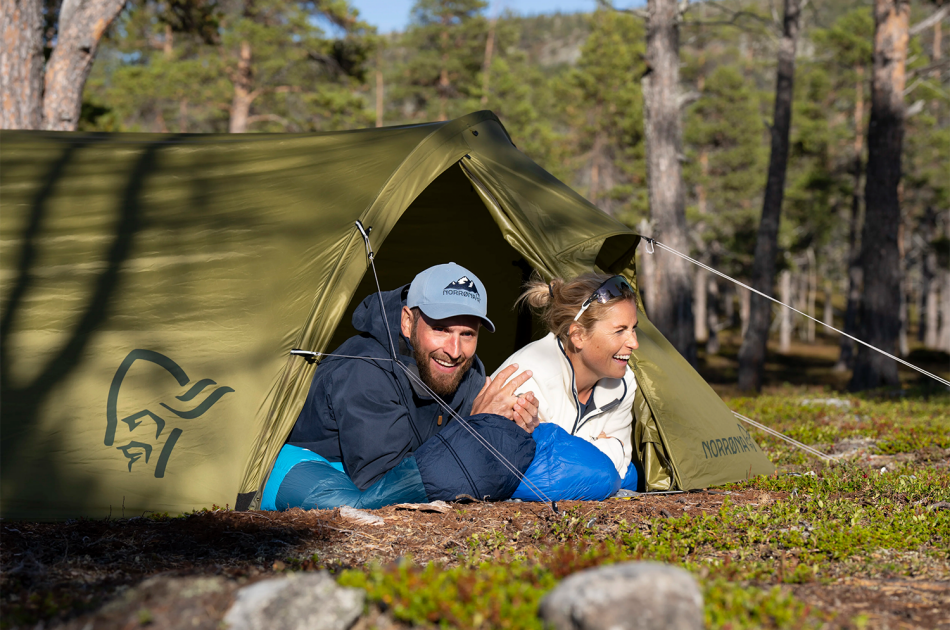 Mann og dame som ligger i telt i skogen