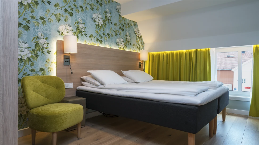 Seng og stol på soverom i suiten på Thon Hotel Tønsberg Brygge