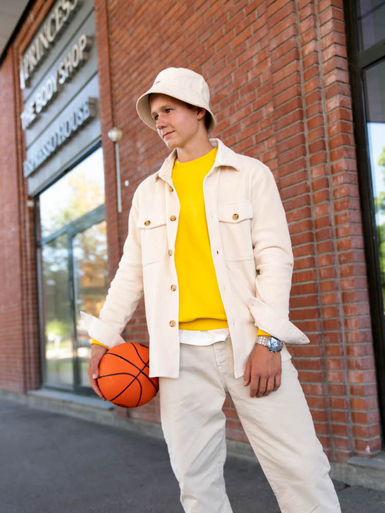 Gutt med hvit jakke, hvit hatt og gul genser