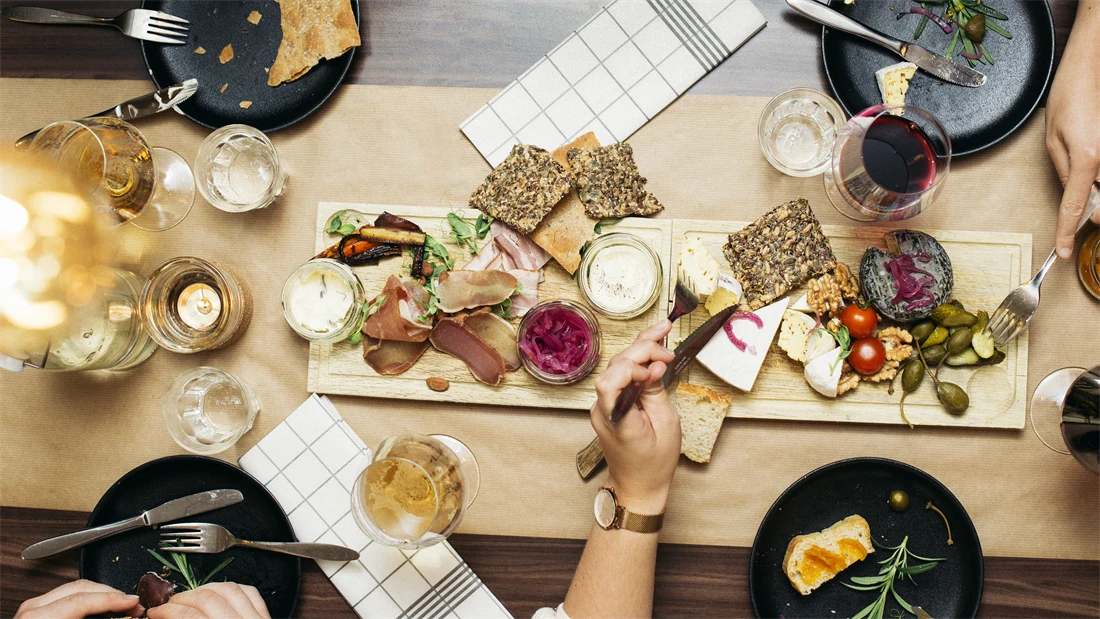 Lyst spisebord dekket med servise og tapasmat. 