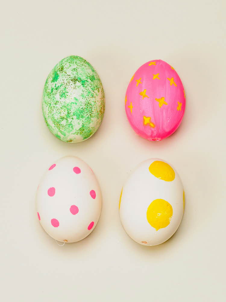 Fire egg dekorert med grønn, rosa og gul maling