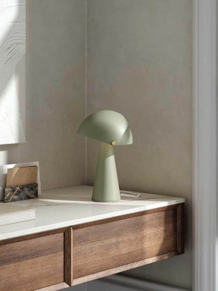 Grønn bordlampe står på et avlastningsbord