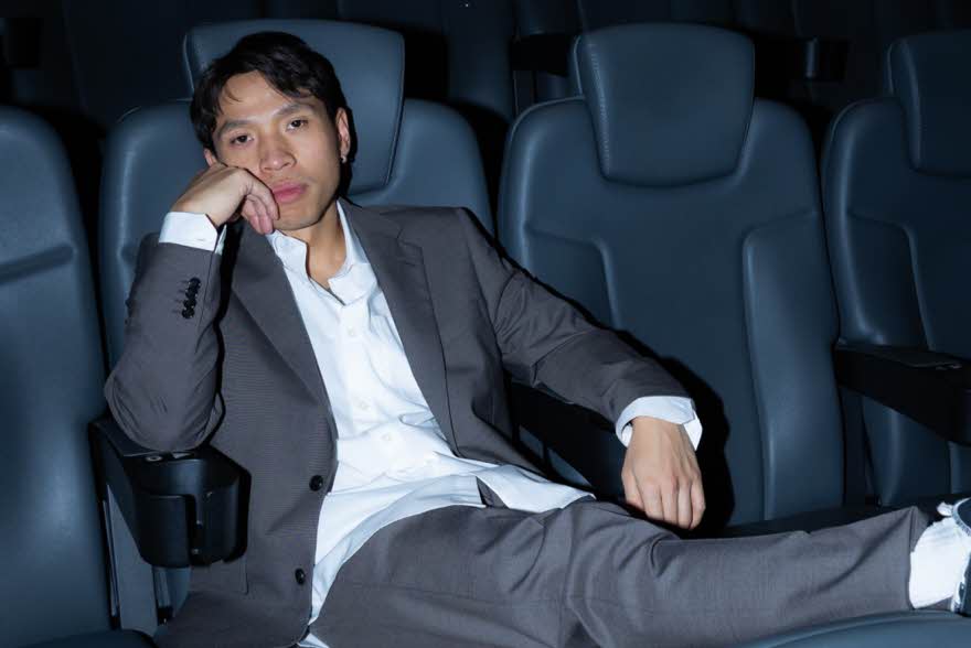 Mann som sitter i kinosal